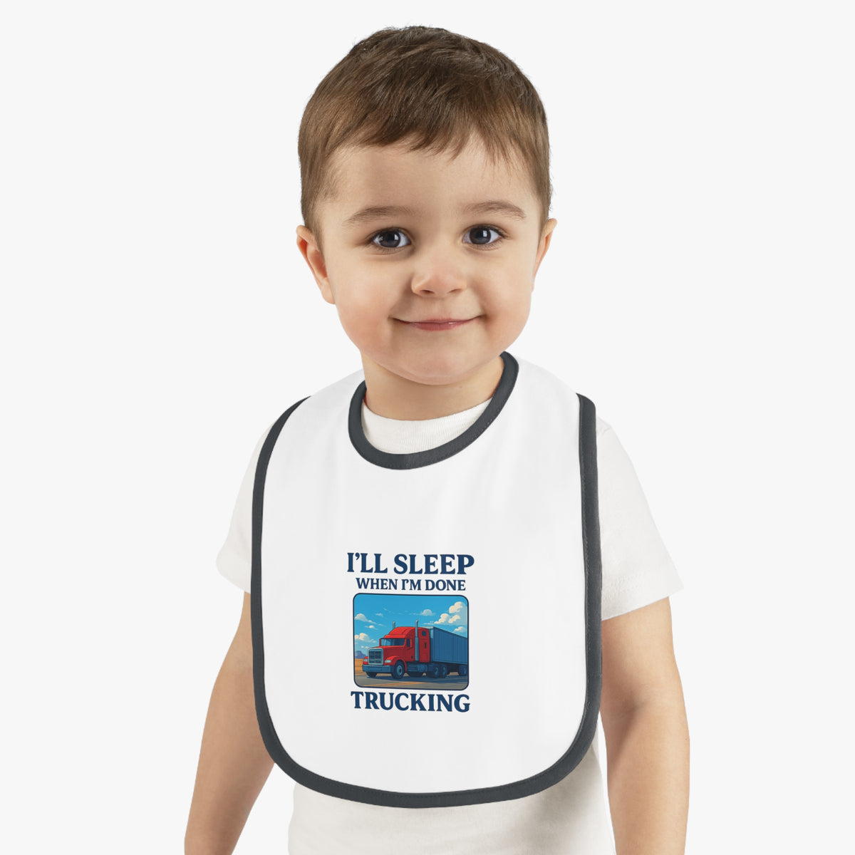 Funny trucking baby bib by Printify with "I'll Sleep When I'm Done" slogan, featuring a white and black design for kids.