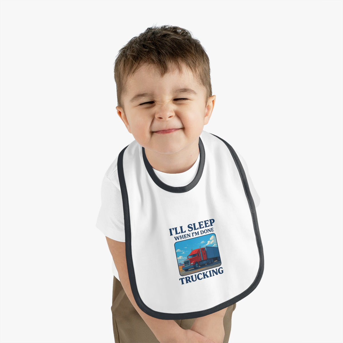 Funny Trucking Baby Bib by Printify featuring "I'll Sleep When I'm Done" text, made for kids, in white and black.