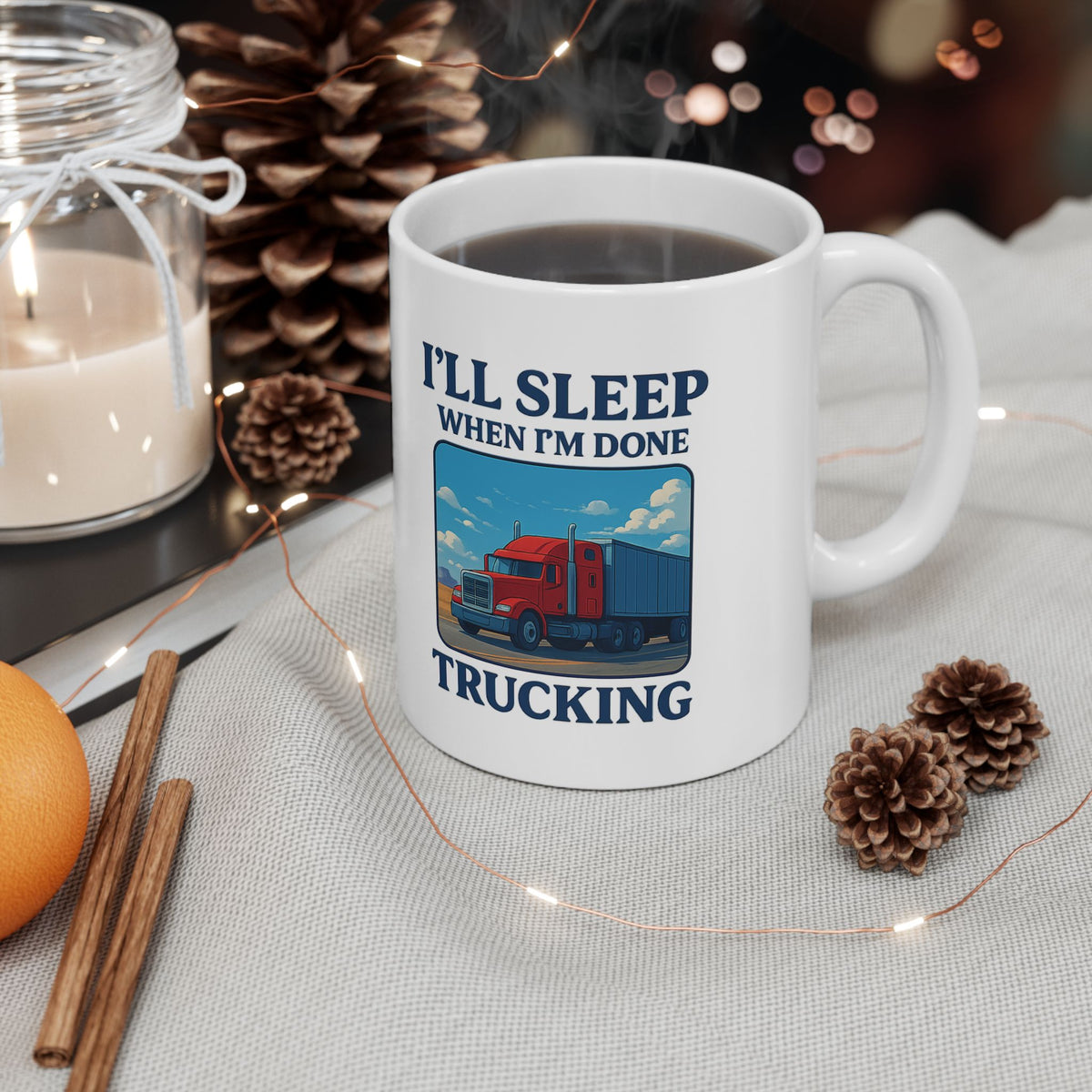 Ceramic truck driver mug with humorous "I’ll Sleep When I’m Done Trucking" slogan, ideal for truckers and gifts.