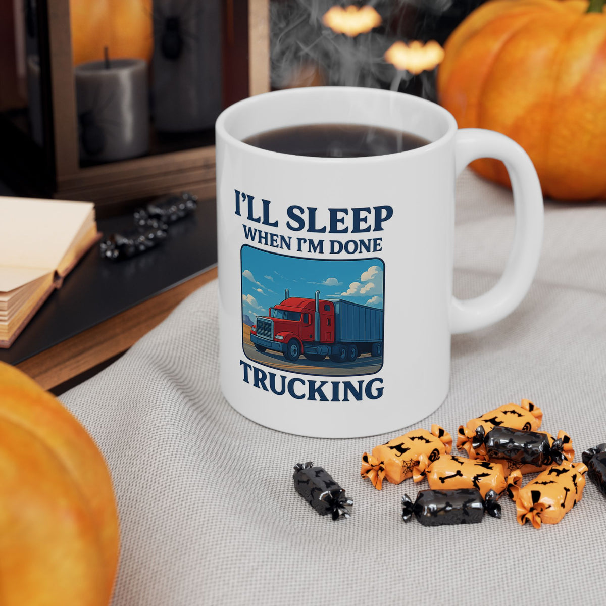 Ceramic mug with truck driver quote "I’ll Sleep When I’m Done Trucking," ideal for truckers, featuring bold black text on white mug.