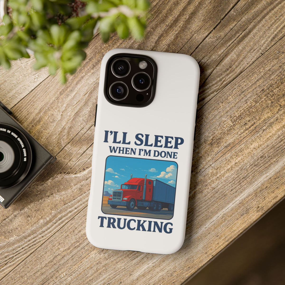 Glossy iPhone 16 Pro trucker phone case with "I'll Sleep When I'm Done Trucking" design by Printify, featuring a trucking-themed graphic.